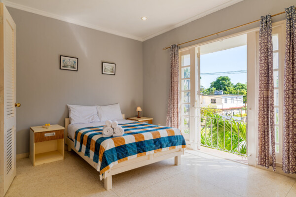 Timur Suite - Double bed, bright natural light and terrazzo floors Miramar Residence – Room Timur with cozy furnishings and city views